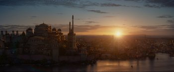Movie still from “Aladdin” (2019), directed by Guy Ritchie – The sun is setting over a large city; Extreme Wide shot, High angle