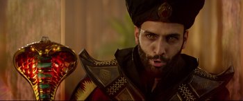 Movie still from “Aladdin” (2019), directed by Guy Ritchie – A man with a beard wearing a turban and holding a sword; Close Up shot, Over the shoulder angle