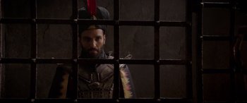 Movie still from “Aladdin” (2019), directed by Guy Ritchie – A man wearing a hat and a suit of armor looking out a window; Close Up shot, Over the shoulder angle