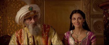Movie still from “Aladdin” (2019), directed by Guy Ritchie – An old man and a young woman are posing for a picture; Medium shot, Over the shoulder angle