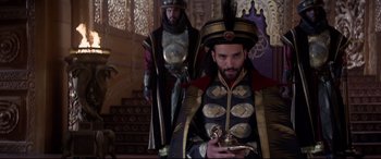 Movie still from “Aladdin” (2019), directed by Guy Ritchie – Two men in costumes are standing in a room; Medium shot, Over the shoulder angle