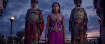 Movie still from “Aladdin” (2019), directed by Guy Ritchie – A group of people standing next to each other on top of a hill; Medium shot, Over the shoulder angle