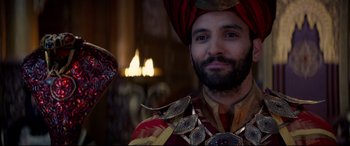 Movie still from “Aladdin” (2019), directed by Guy Ritchie – A man wearing a turban and a red and gold outfit; Close Up shot, Over the shoulder angle