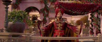 Movie still from “Aladdin” (2019), directed by Guy Ritchie – A man dressed in a red and gold costume; Wide shot, Low angle
