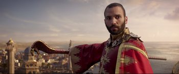 Movie still from “Aladdin” (2019), directed by Guy Ritchie – A man in a red and gold outfit holding a sword; Medium shot, Low angle