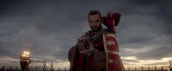 Movie still from “Aladdin” (2019), directed by Guy Ritchie – A man holding a cat and a bird on his shoulder; Medium shot, Low angle