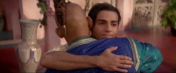Movie still from “Aladdin” (2019), directed by Guy Ritchie – A man hugging another man in a blue shirt; Close Up shot, Over the shoulder angle