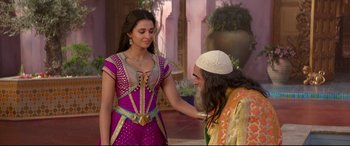 Movie still from “Aladdin” (2019), directed by Guy Ritchie – A woman and a bearded man are standing in a room; Medium shot, Over the shoulder angle