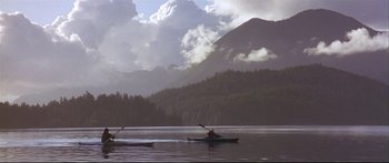 Movie still from “Alaska” (1996), directed by Fraser C. Heston – A couple of people in a boat on a body of water; Extreme Wide shot, High angle