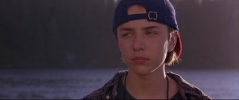 Movie still from “Alaska” (1996), directed by Fraser C. Heston – A boy with a blue hat is looking to his left; Close Up shot, Over the shoulder angle