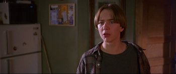 Movie still from “Alaska” (1996), directed by Fraser C. Heston – A young man in a plaid shirt is looking at the camera; Close Up shot, Low angle