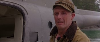 Movie still from “Alaska” (1996), directed by Fraser C. Heston – A person wearing a hat near an airplane; Close Up shot, Low angle