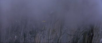 Movie still from “Alaska” (1996), directed by Fraser C. Heston – A yellow plane flying over a cliff in the fog; Extreme Wide shot, High angle