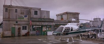 Movie still from “Alaska” (1996), directed by Fraser C. Heston – A helicopter parked in front of a building; Extreme Wide shot, Low angle