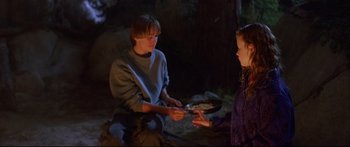Movie still from “Alaska” (1996), directed by Fraser C. Heston – A man and a woman holding a pan of food; Medium shot, High angle