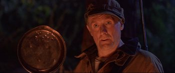Movie still from “Alaska” (1996), directed by Fraser C. Heston – An old man with a hat is holding a pan; Close Up shot, Low angle