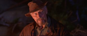 Movie still from “Alaska” (1996), directed by Fraser C. Heston – An older man wearing a brown hat and a brown jacket; Close Up shot, Over the shoulder angle