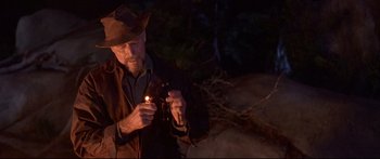 Movie still from “Alaska” (1996), directed by Fraser C. Heston – An old man holding a flashlight in the dark; Medium shot, Over the shoulder angle