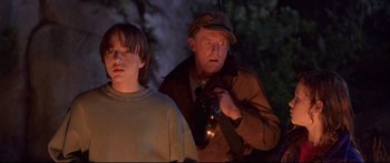 Movie still from “Alaska” (1996), directed by Fraser C. Heston – A man and a boy are standing in the dark; Medium shot, Low angle