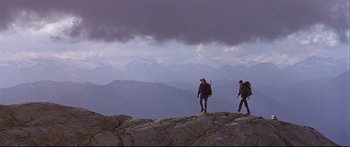 Movie still from “Alaska” (1996), directed by Fraser C. Heston – Two people are walking on a rocky mountain side; Wide shot, Low angle