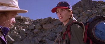 Movie still from “Alaska” (1996), directed by Fraser C. Heston – A man in a baseball cap is standing in front of a pile of rocks; Close Up shot, Low angle