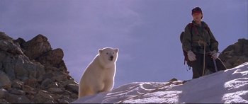 Movie still from “Alaska” (1996), directed by Fraser C. Heston – A white polar bear sitting on top of a snow covered slope; Wide shot, Low angle