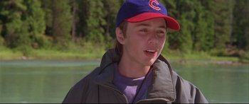 Movie still from “Alaska” (1996), directed by Fraser C. Heston – A young man wearing a baseball cap and jacket; Close Up shot, High angle