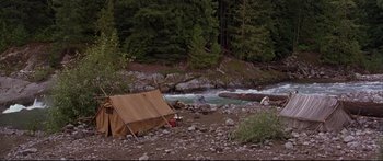 Movie still from “Alaska” (1996), directed by Fraser C. Heston – A tent set up in the middle of a river; Extreme Wide shot, High angle