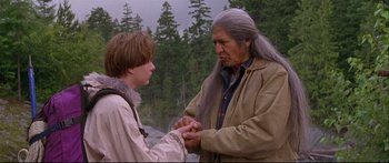 Movie still from “Alaska” (1996), directed by Fraser C. Heston – A man and a young boy are holding hands; Medium shot, Over the shoulder angle