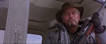 Movie still from “Alaska” (1996), directed by Fraser C. Heston – An older man wearing a hat in a vehicle; Close Up shot, Low angle