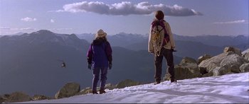 Movie still from “Alaska” (1996), directed by Fraser C. Heston – A couple of people standing on top of a snow covered slope; Wide shot, Low angle