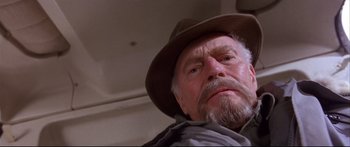 Movie still from “Alaska” (1996), directed by Fraser C. Heston – An older man wearing a brown hat and a gray jacket; Close Up shot, Low angle