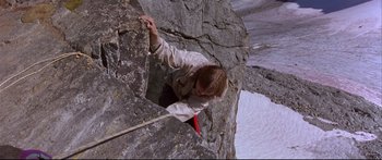Movie still from “Alaska” (1996), directed by Fraser C. Heston – A man climbing up a rock wall on a mountain; Wide shot, High angle
