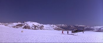 Movie still from “Alaska” (1996), directed by Fraser C. Heston – Two people are skiing on a snowy slope; Extreme Wide shot, High angle