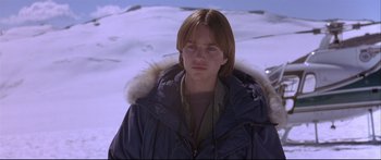 Movie still from “Alaska” (1996), directed by Fraser C. Heston – A man in a parka standing on top of a snow covered slope; Close Up shot, Low angle