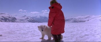Movie still from “Alaska” (1996), directed by Fraser C. Heston – A woman in a red coat standing next to a polar bear; Wide shot, High angle