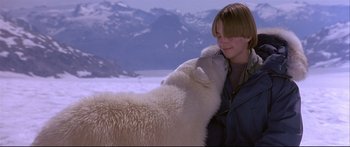 Movie still from “Alaska” (1996), directed by Fraser C. Heston – A woman is petting a polar bear on the nose; Medium shot, Low angle