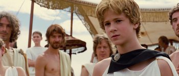 Movie still from “Alexander” (2004), directed by Oliver Stone – A young man with a beard stands next to two other men; Close Up shot, Over the shoulder angle