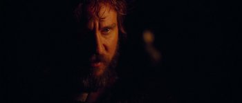 Movie still from “Alexander” (2004), directed by Oliver Stone – A person with a beard looking at the camera; Close Up shot, Over the shoulder angle