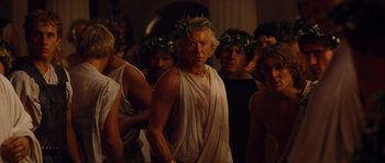 Movie still from “Alexander” (2004), directed by Oliver Stone – A group of men standing next to each other wearing wreaths on their heads; Medium shot, High angle