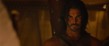 Movie still from “Alexander” (2004), directed by Oliver Stone – A person with long black hair; Close Up shot, Over the shoulder angle