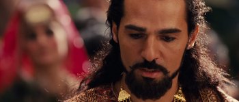 Movie still from “Alexander” (2004), directed by Oliver Stone – A person with long black hair and a beard; Close Up shot, High angle