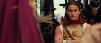Movie still from “Alexander” (2004), directed by Oliver Stone – A man dressed as a roman soldier in a red and gold outfit; Close Up shot, Over the shoulder angle