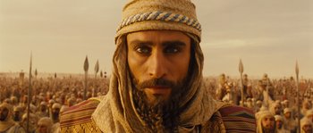 Movie still from “Alexander” (2004), directed by Oliver Stone – A person with a beard wearing a hat; Close Up shot, High angle
