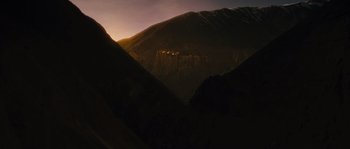 Movie still from “Alexander” (2004), directed by Oliver Stone – The sun is setting over a mountain range; Extreme Wide shot, Low angle