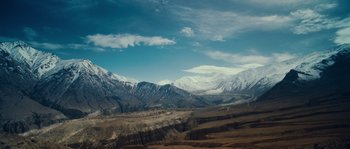 Movie still from “Alexander” (2004), directed by Oliver Stone – A view of a mountain range with snow on it's tops; Extreme Wide shot, Low angle