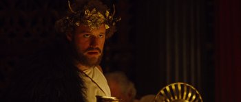 Movie still from “Alexander” (2004), directed by Oliver Stone – A man wearing a crown and holding a cup; Close Up shot, Over the shoulder angle