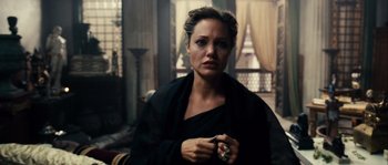 Movie still from “Alexander” (2004), directed by Oliver Stone – A woman in a black dress holding a ring; Close Up shot, Over the shoulder angle