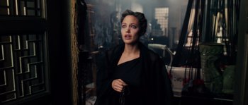 Movie still from “Alexander” (2004), directed by Oliver Stone – A woman wearing a black dress and holding a rosary; Close Up shot, Over the shoulder angle