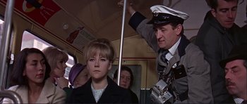 Movie still from “Alfie” (1966), directed by Lewis Gilbert – A woman in a black coat and a man in a white hat; Medium shot, Low angle